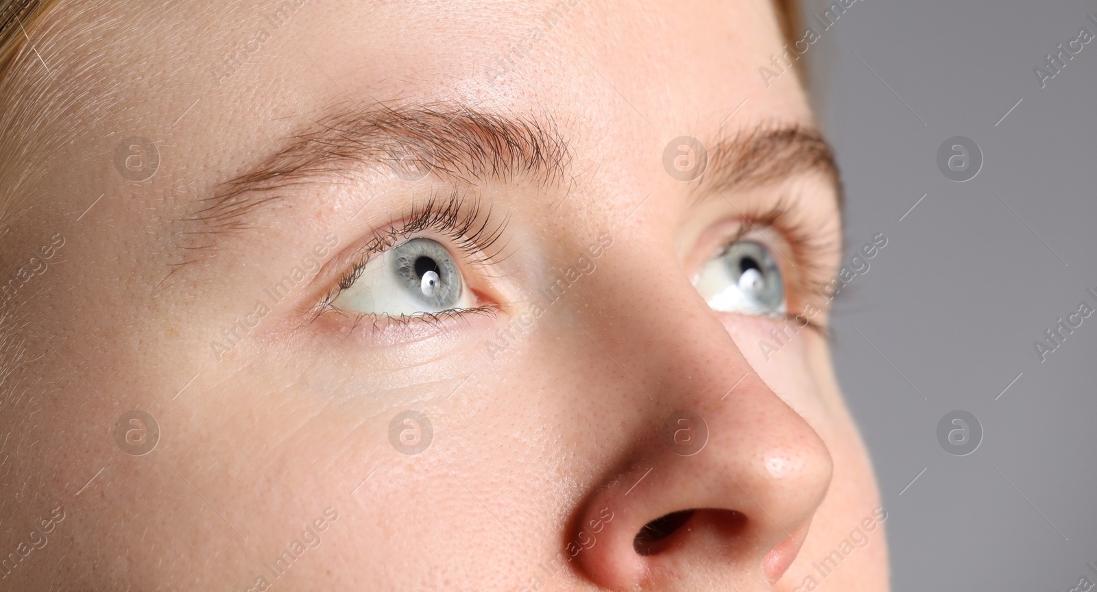 Photo of Woman with beautiful eyes on light grey background, closeup