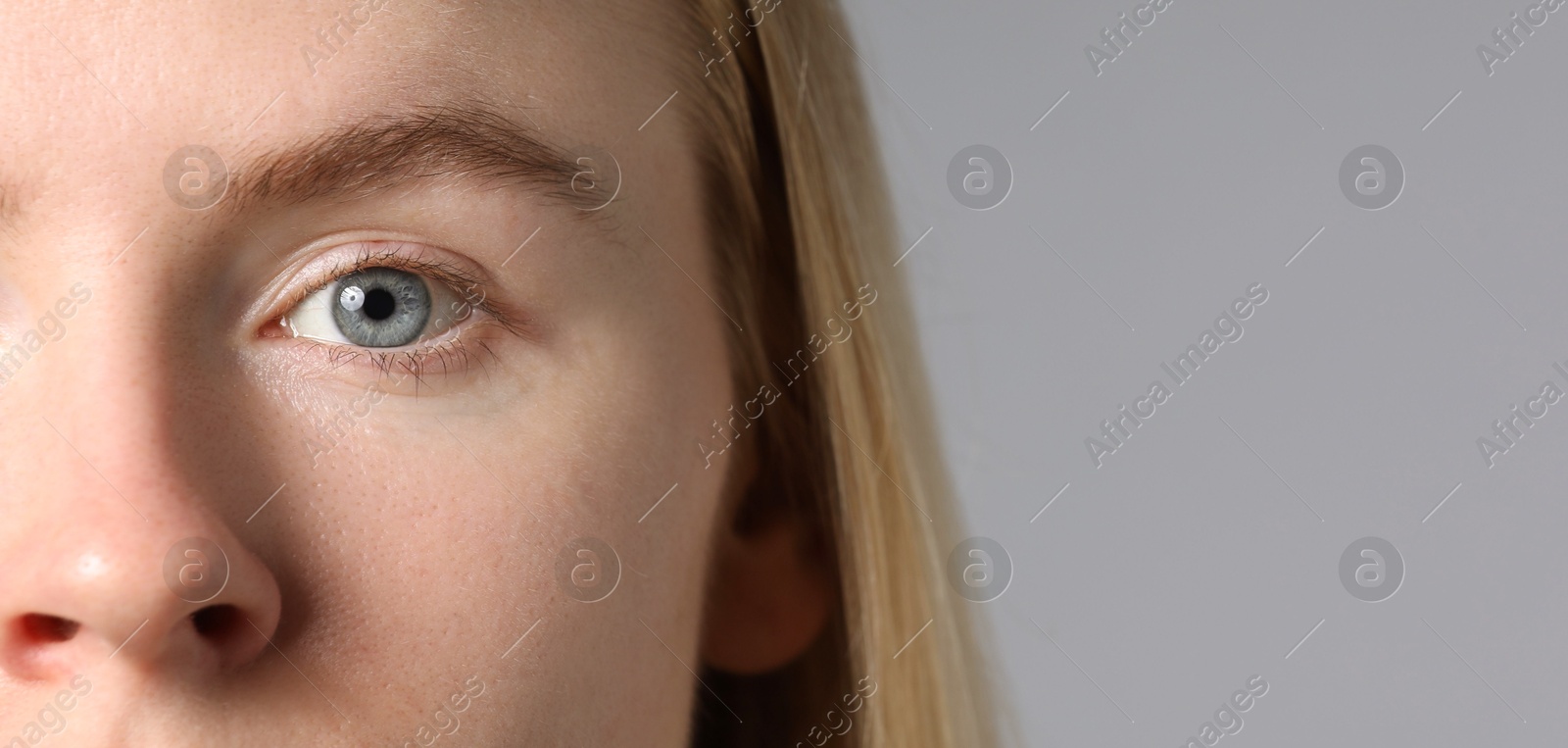 Photo of Woman with beautiful eyes on light grey background, closeup. Space for text