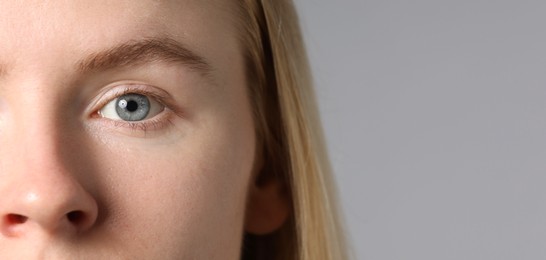Photo of Woman with beautiful eyes on light grey background, closeup. Space for text