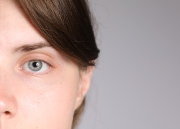 Photo of Woman with beautiful eyes on light grey background, closeup. Space for text