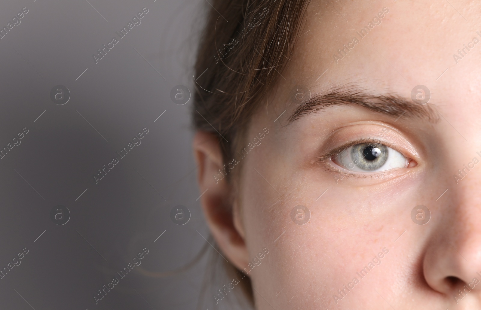 Photo of Woman with beautiful eyes on light grey background, closeup. Space for text
