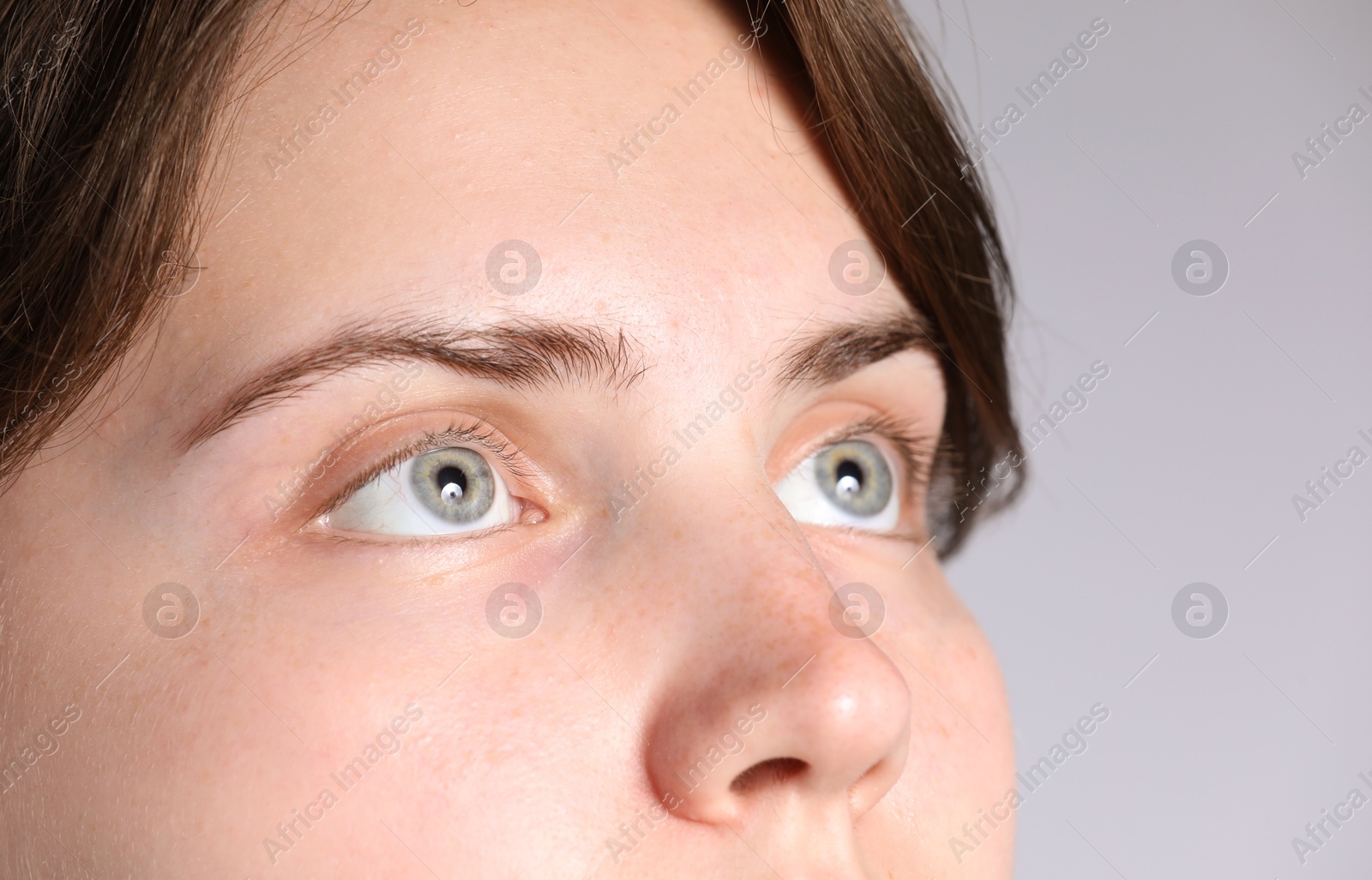 Photo of Woman with beautiful eyes on light grey background, closeup