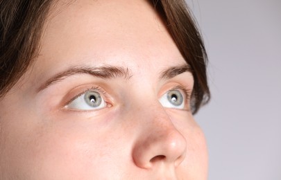 Photo of Woman with beautiful eyes on light grey background, closeup