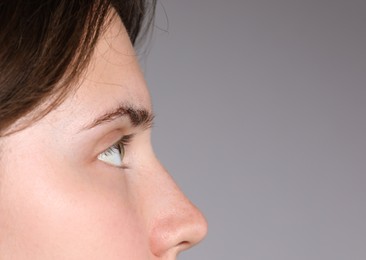 Photo of Woman with beautiful eyes on light grey background, closeup. Space for text