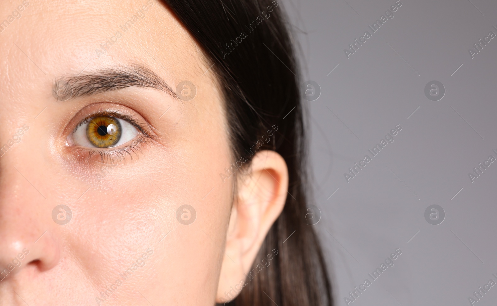Photo of Woman with beautiful eyes on light grey background, closeup. Space for text
