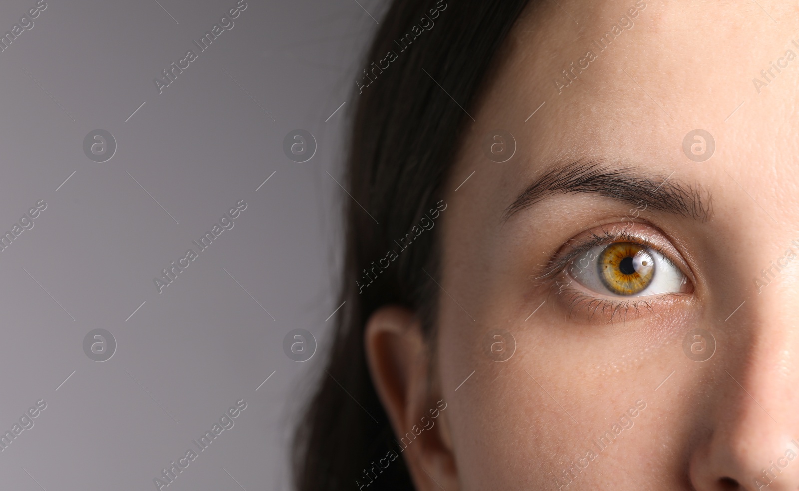 Photo of Woman with beautiful eyes on light grey background, closeup. Space for text