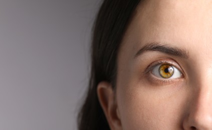 Photo of Woman with beautiful eyes on light grey background, closeup. Space for text