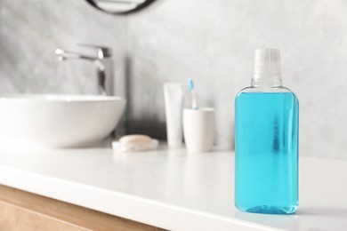 Photo of Bottle of mouthwash on white counter in bathroom. Space for text