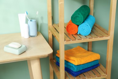 Photo of Fresh colorful terry towels and hygiene products in bathroom