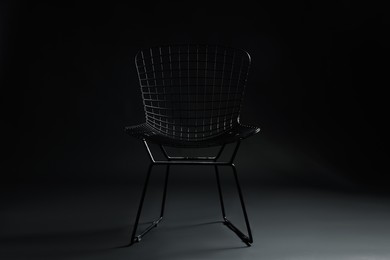 Photo of Stylish chair on black background. Used stuff