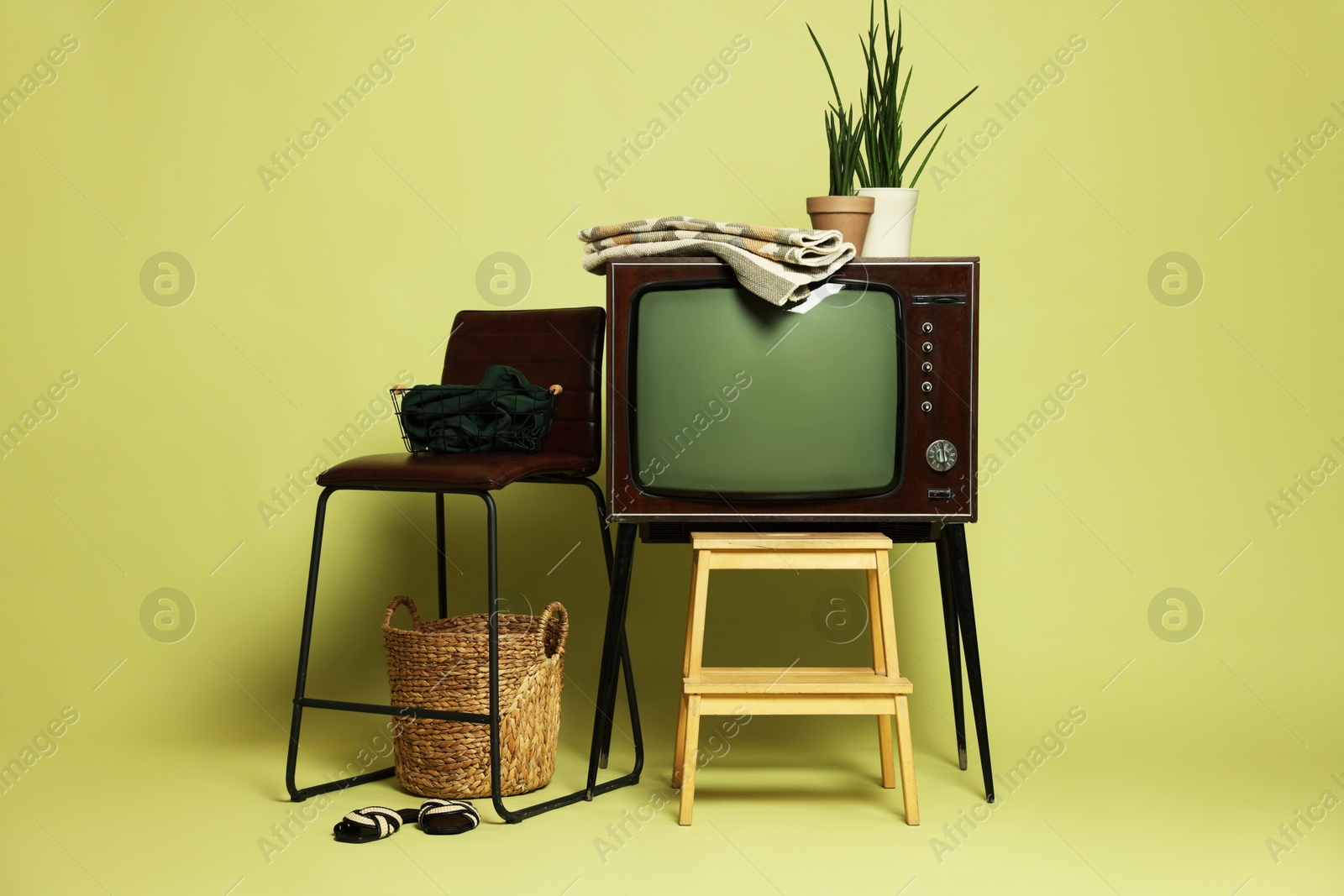 Photo of Retro TV set and other used stuff on olive background