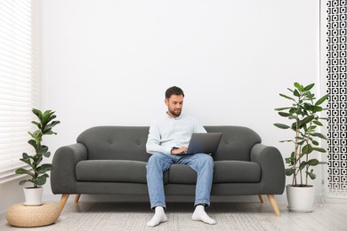 Photo of Man with laptop on sofa at home