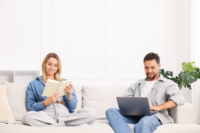 Photo of Happy couple spending time enjoying their hobbies on sofa at home