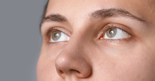 Photo of Woman with beautiful eyes on light grey background, closeup