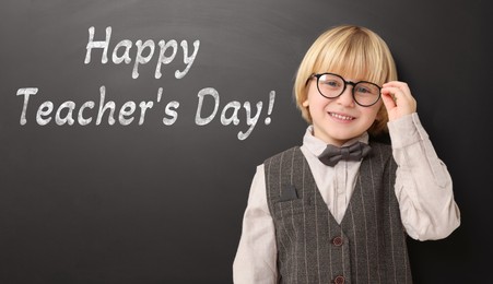 Image of Happy Teacher's Day. Cute little boy with eyeglasses near black board