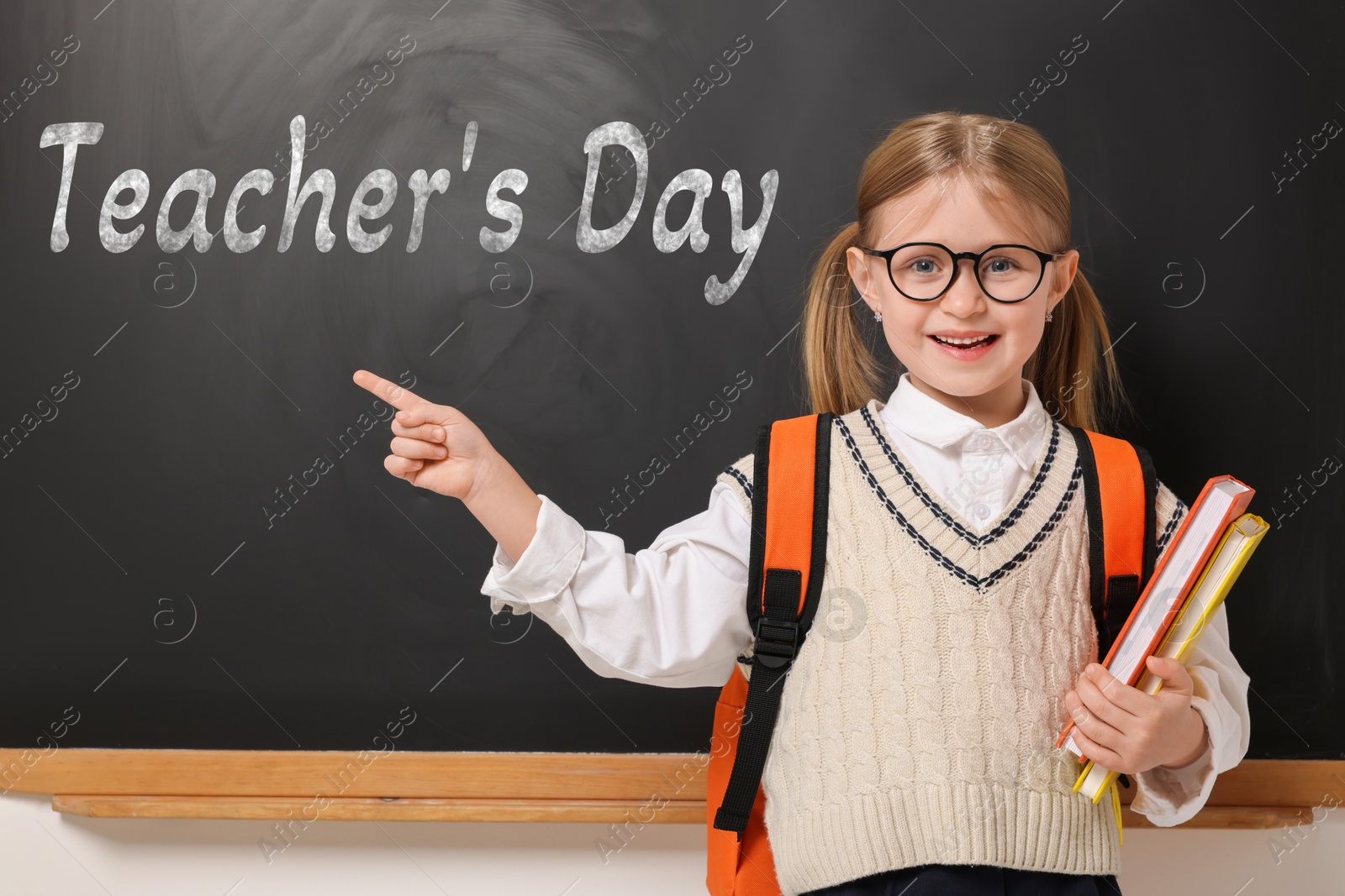 Happy Teacher's Day. Cute little girl with eyeglasses near blackboard Image of Happy Teacher's Day. Cute little girl with eyeglasses near blackboard