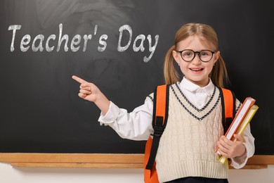 Image of Happy Teacher's Day. Cute little girl with eyeglasses near blackboard