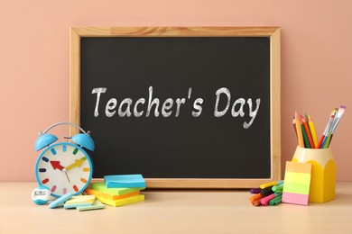 Image of Happy Teacher's Day greeting card with stationery and text on small chalkboard
