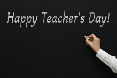 Image of Happy Teacher's Day greeting card. Woman writing text on blackboard, closeup