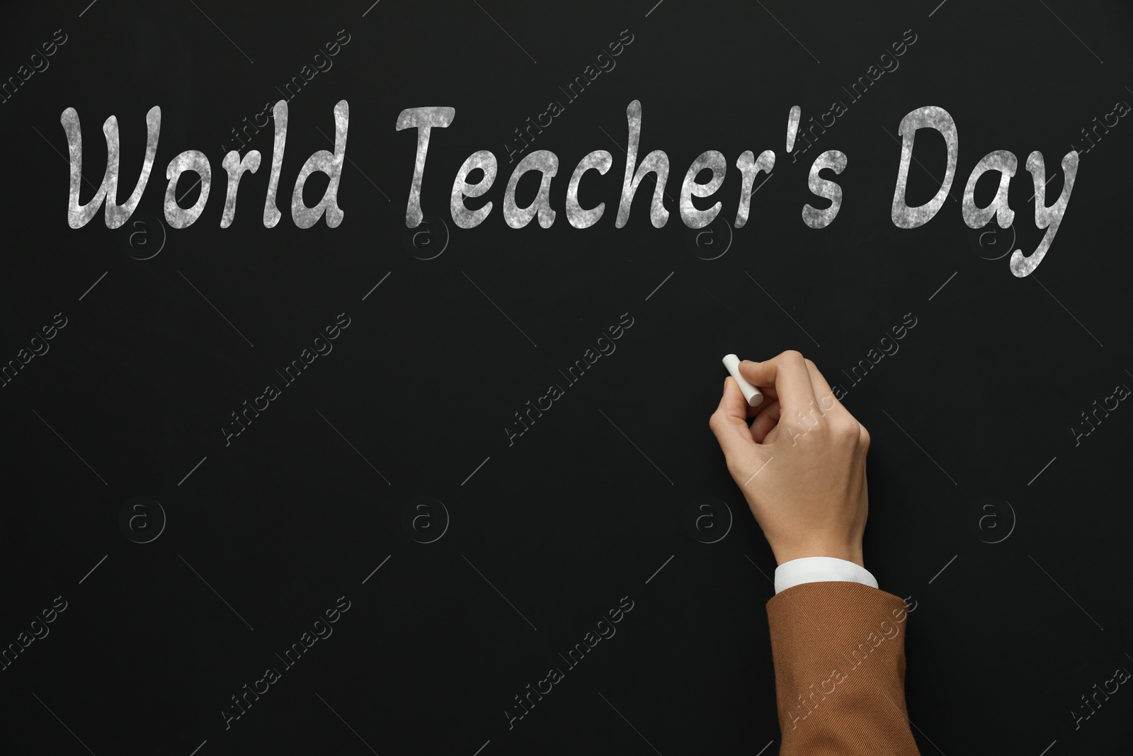 Happy Teacher's Day greeting card. Woman writing text on blackboard, closeup Image of Happy Teacher's Day greeting card. Woman writing text on blackboard, closeup