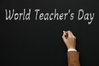 Image of Happy Teacher's Day greeting card. Woman writing text on blackboard, closeup
