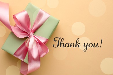 Image of Thank you card design with gift box on dark beige background, bokeh effect