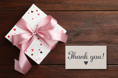 Image of Thank you card and gift box on wooden background