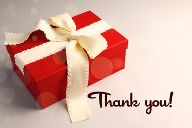 Image of Thank you card design with gift box on light background, bokeh effect