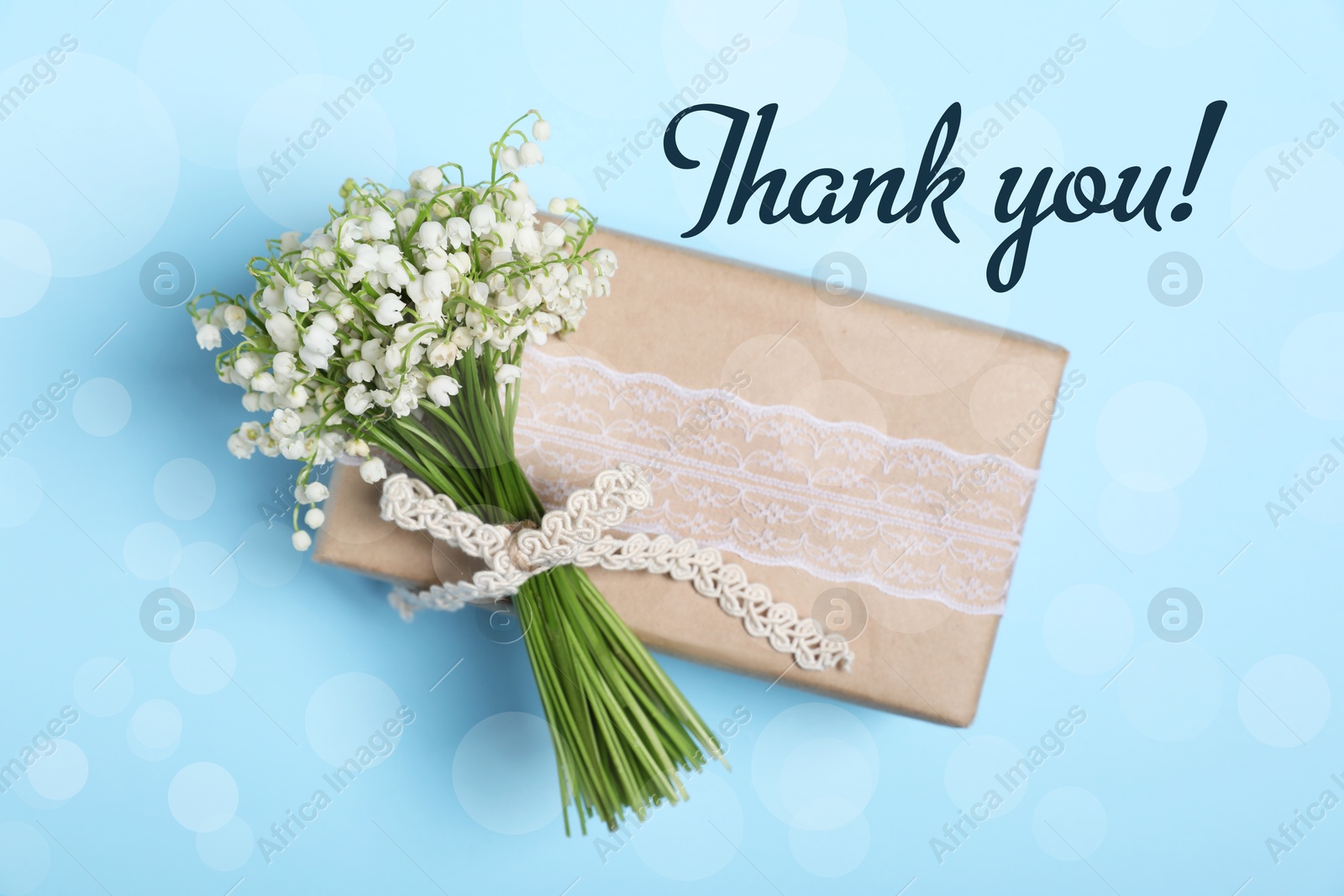 Image of Thank you card design with gift box and flowers on light blue background. Bokeh effect