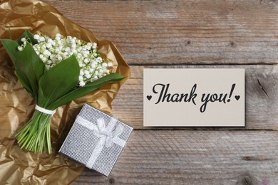 Image of Thank you card, flowers and gift box on wooden background