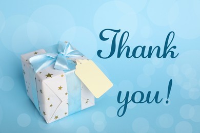 Image of Thank you card design with gift box on light blue background. Bokeh effect