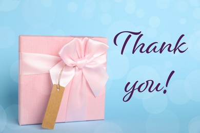 Image of Thank you card design with gift box on light blue background. Bokeh effect