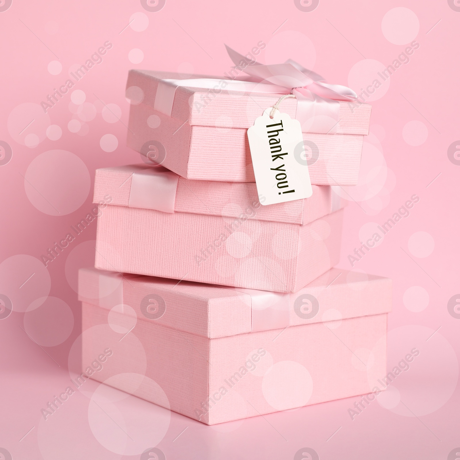 Image of Gift boxes and Thank You tag on pink background. Bokeh effect
