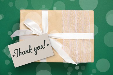 Image of Thank you card and gift box on green background. Bokeh effect