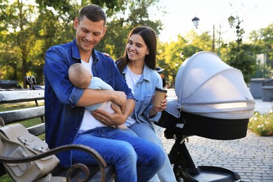 Photo of Happy parents with their baby on bench in park