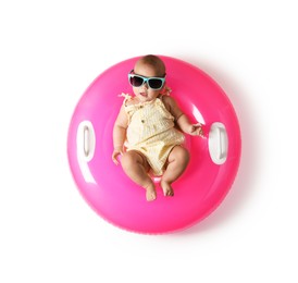 Photo of Cute little baby in sunglasses with inflatable ring on white background, top view