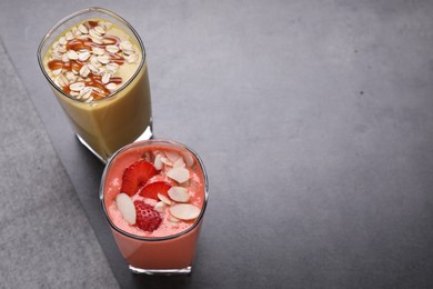Photo of Different delicious smoothies on grey table, above view. Space for text