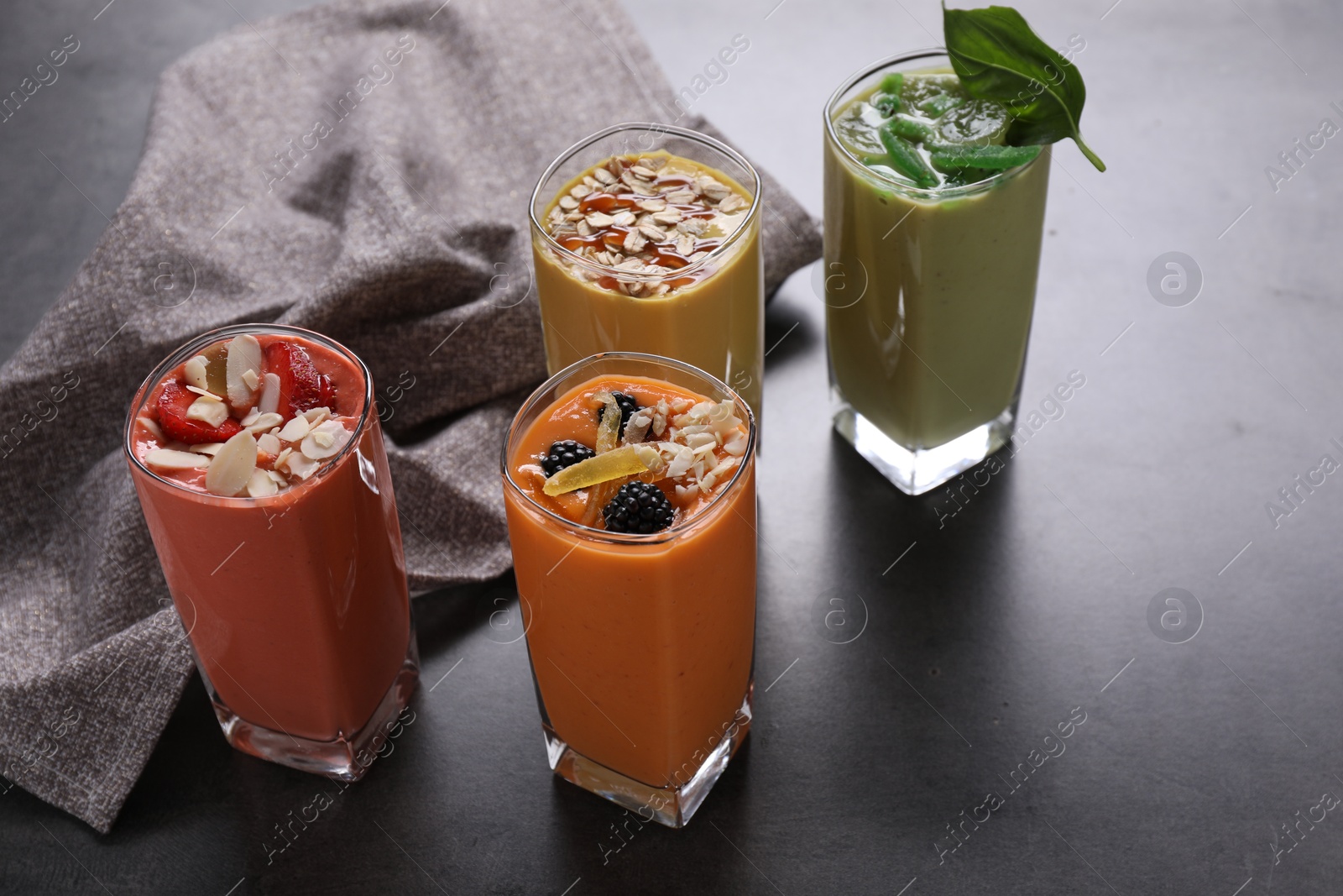 Photo of Many different delicious smoothies on grey table