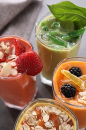 Photo of Many different delicious smoothies on grey table, closeup