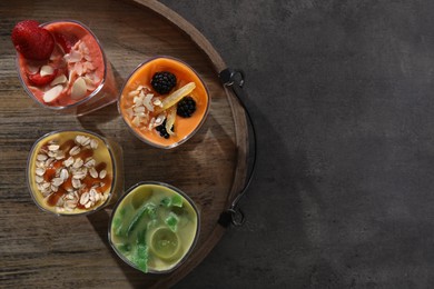 Photo of Tray with many different delicious smoothies on grey table, top view. Space for text
