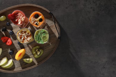 Photo of Tray with many different delicious smoothies and ingredients on grey table, top view. Space for text