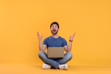 Photo of Emotional man with laptop on yellow background