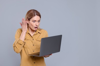 Photo of Emotional woman with laptop on light grey background. Space for text