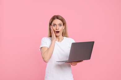 Photo of Emotional woman with laptop on pink background