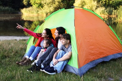 Photo of Happy family spending time together with camping tent outdoors