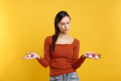 Photo of Woman choosing between glasses and contact lenses on orange background