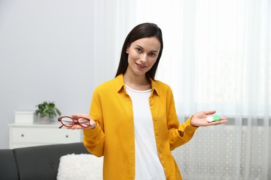 Photo of Woman choosing between glasses and contact lenses indoors