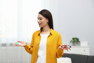 Photo of Woman choosing between glasses and contact lenses indoors