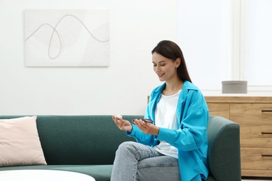 Photo of Woman choosing between glasses and contact lenses on sofa indoors, space for text
