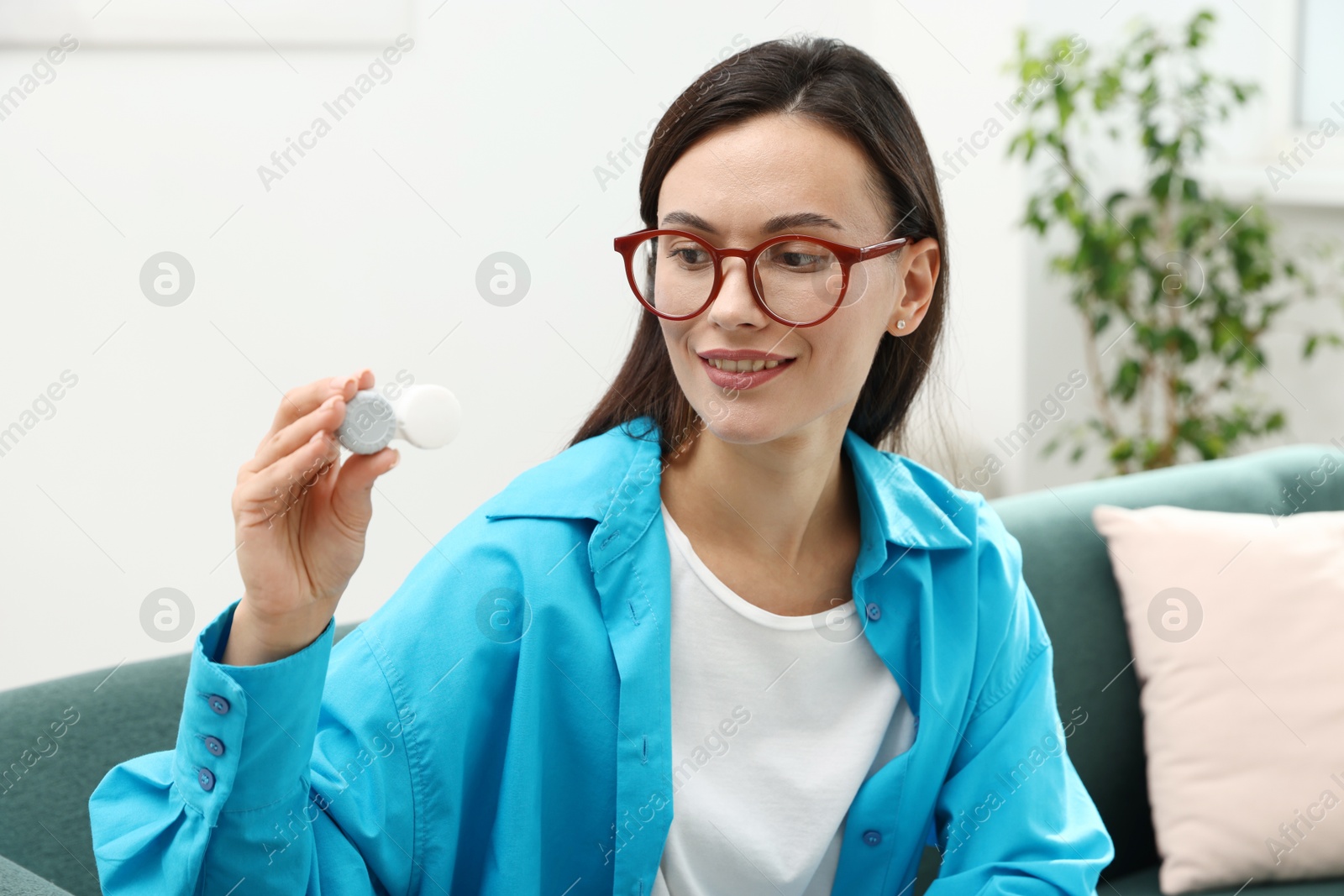 Photo of Woman in glasses with contact lenses on sofa indoors